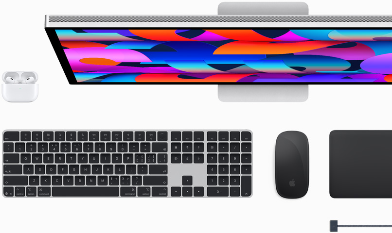 一组 Mac 配件，包括 AirPods、Studio Display、妙控键盘，以及午夜色的妙控鼠标、妙控板、MagSafe 充电线