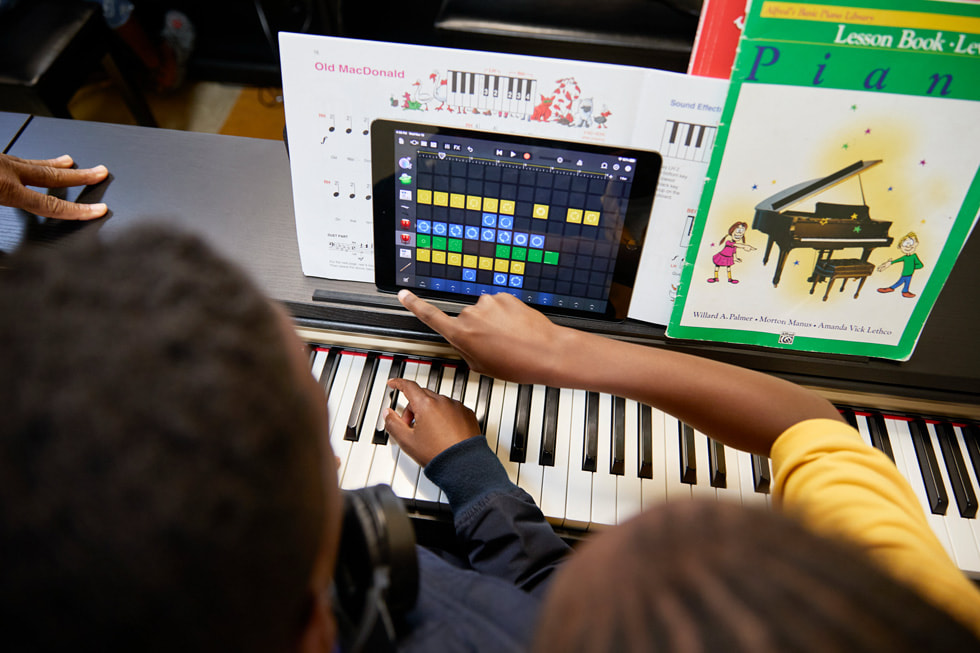 在 Ellis Marsalis 中心的钢琴课上，学生们在钢琴旁使用 iPad。